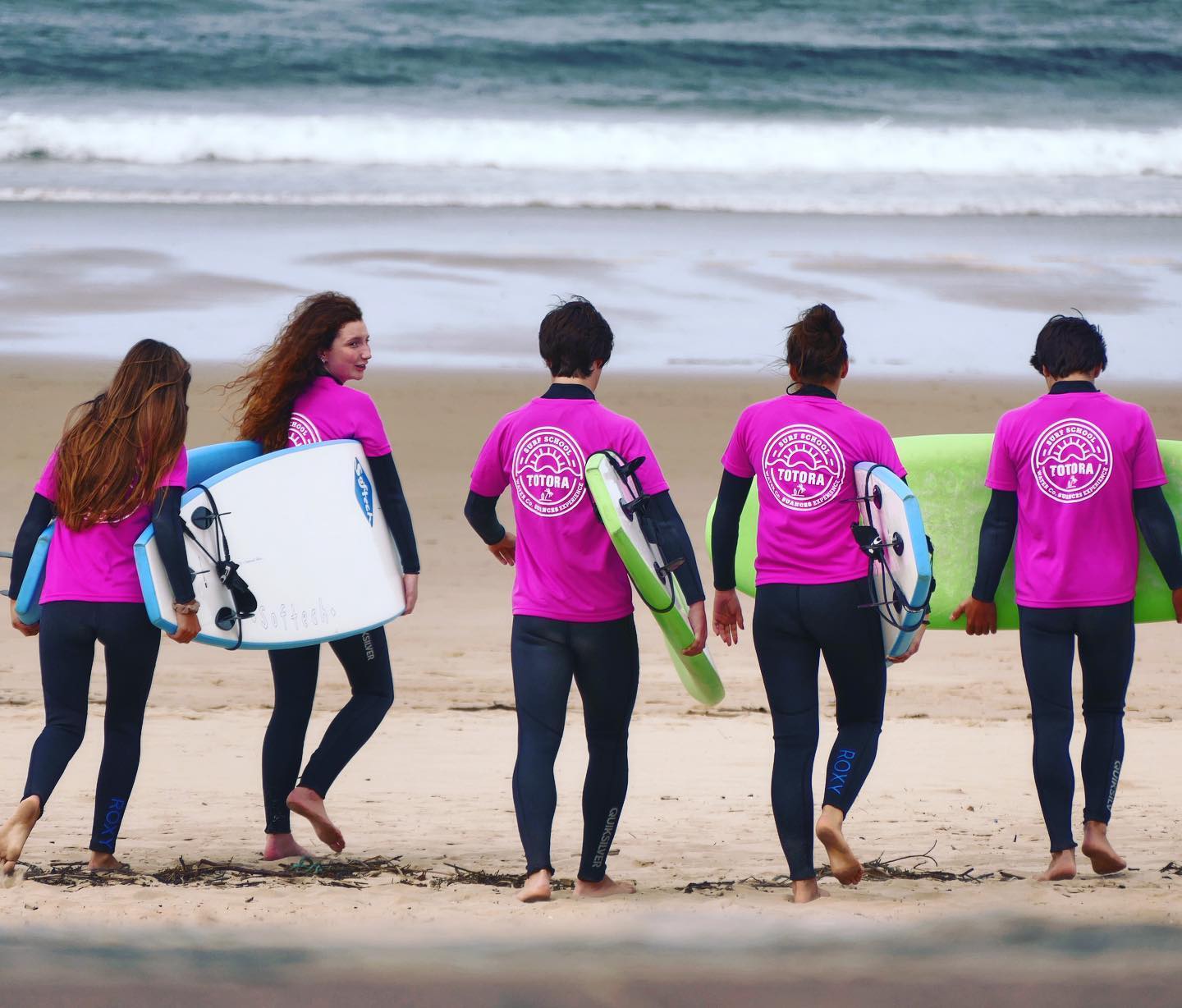 Alumnos de la escuela de Surf de Totora Surf School, en Suances dispuestos a entrar en el agua con sus tablas.